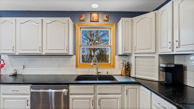 21151 150th St, Sauk Centre, MN 56378 - kitchen with stainless steel dishwasher, a sink, white cabinetry, decorative backsplash, and a textured ceiling