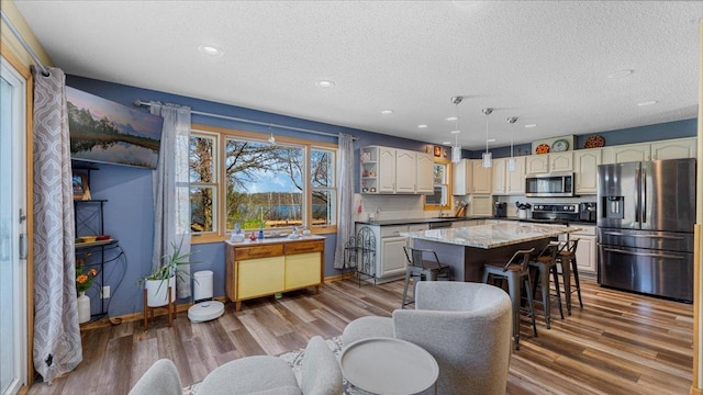 21151 150th St, Sauk Centre, MN 56378 - kitchen with appliances with stainless steel finishes, a textured ceiling, a kitchen island, wood finished floors, and recessed lighting