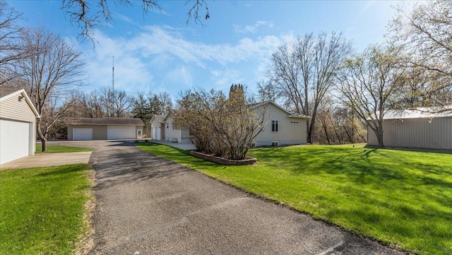 21151 150th St, Sauk Centre, MN 56378 - view of front of home featuring a detached garage, a front lawn, and an outbuilding