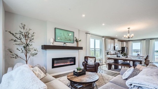 13665 Marsh View Trl, Rogers, MN 55374 - living area with recessed lighting, a notable chandelier, a glass covered fireplace, and light wood-style flooring