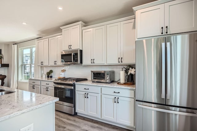 13665 Marsh View Trl, Rogers, MN 55374 - kitchen with appliances with stainless steel finishes, tasteful backsplash, a toaster, light wood finished floors, and recessed lighting
