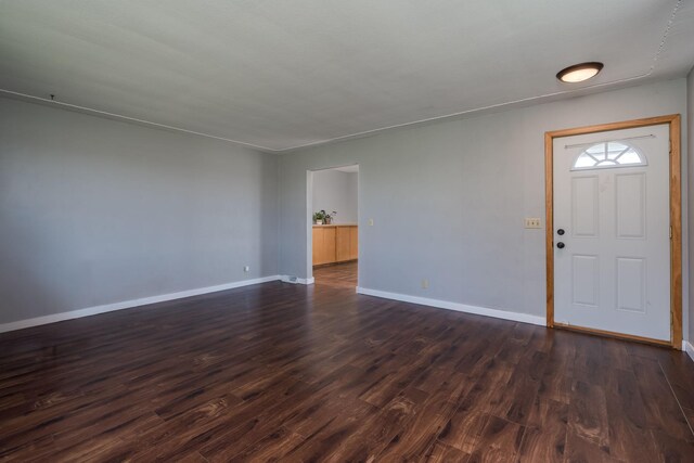 interior space featuring baseboards and dark wood-style floors