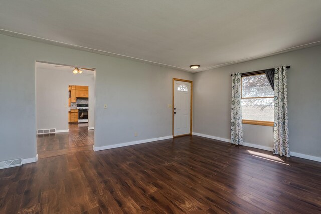 interior space with baseboards, dark wood finished floors, and visible vents