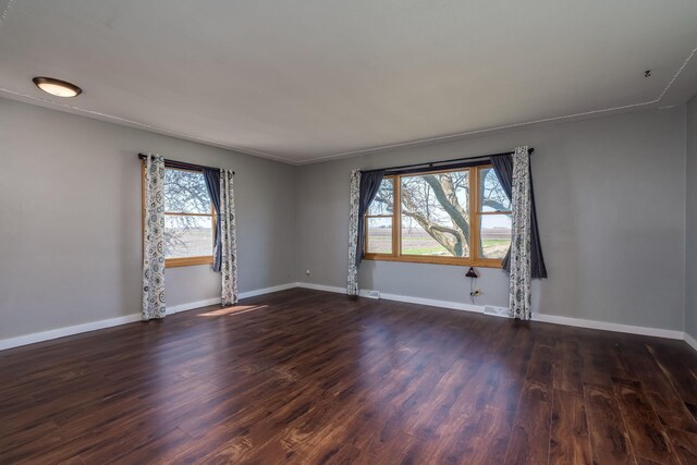 empty room with baseboards and dark wood-style floors