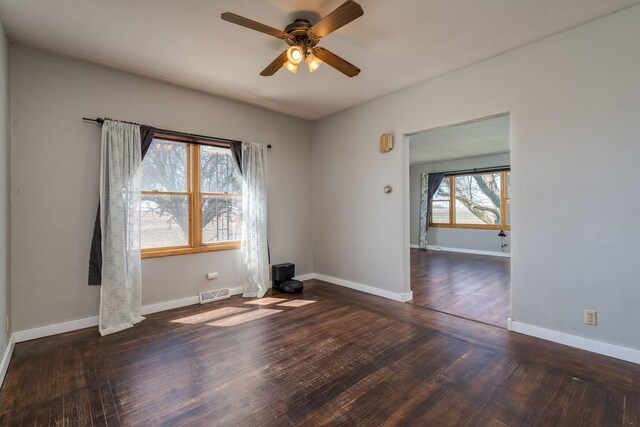 spare room with baseboards, ceiling fan, wood finished floors, and visible vents