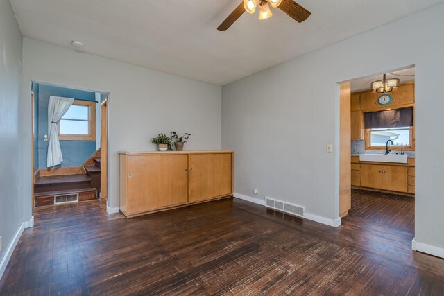 spare room with visible vents, a sink, dark wood-style flooring, and a ceiling fan