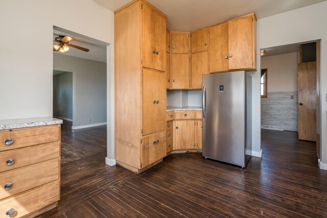 kitchen with freestanding refrigerator, ceiling fan, dark wood-type flooring, and light countertops