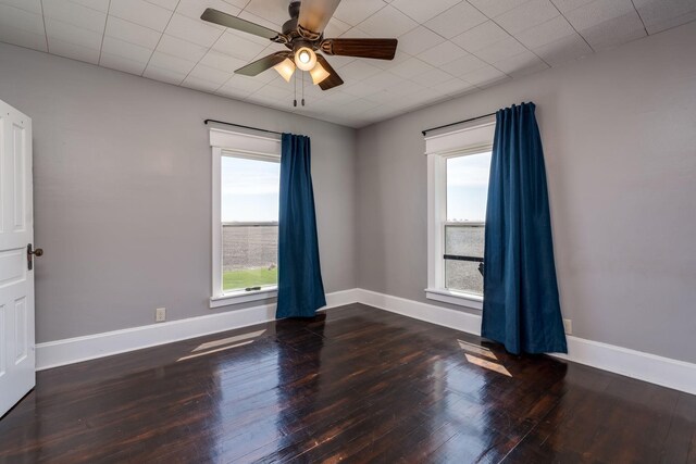 empty room featuring wood-type flooring, ceiling fan, and baseboards