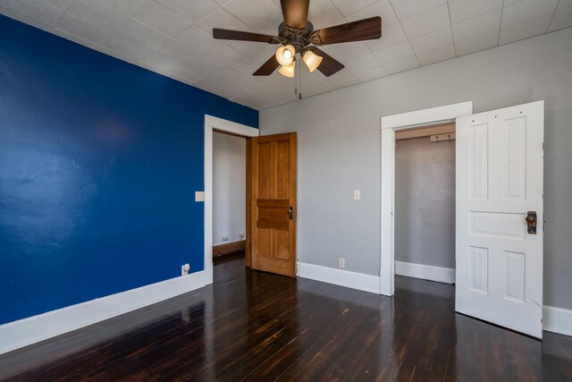 unfurnished bedroom with baseboards, a ceiling fan, a closet, and hardwood / wood-style floors