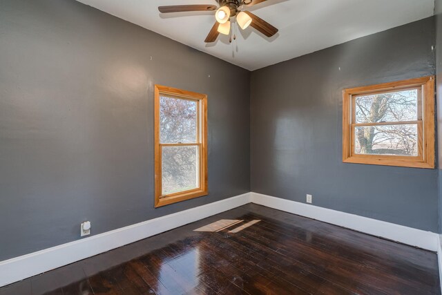 empty room with wood-type flooring, a ceiling fan, baseboards, and plenty of natural light