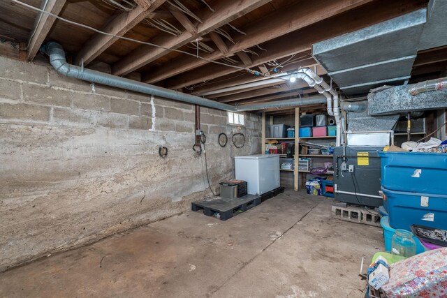 unfinished basement with fridge