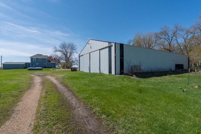 view of pole building with a yard and dirt driveway