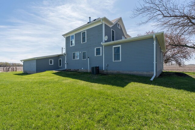 rear view of property with a yard and cooling unit