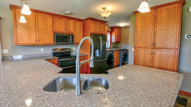 1431 Beech St, Saint Paul, MN 55106 - kitchen with stainless steel appliances, a sink, separate washer and dryer, brown cabinetry, and pendant lighting