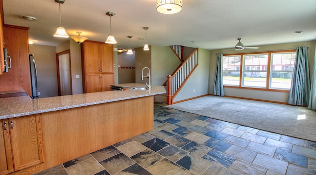 1431 Beech St, Saint Paul, MN 55106 - kitchen featuring a sink, baseboards, a peninsula, ceiling fan, and brown cabinets