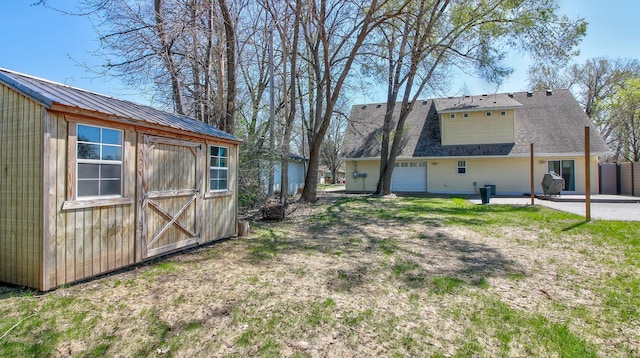 1431 Beech St, Saint Paul, MN 55106 - view of home's exterior featuring a patio, a shingled roof, and a garage
