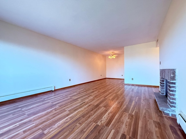 unfurnished living room featuring baseboards, wood finished floors, and a fireplace