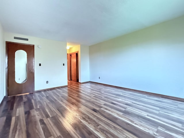 unfurnished living room featuring baseboards and wood finished floors