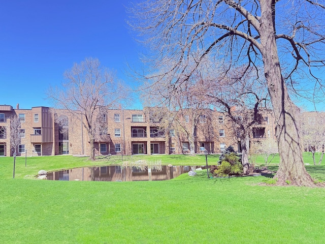 view of community featuring a lawn and a water view