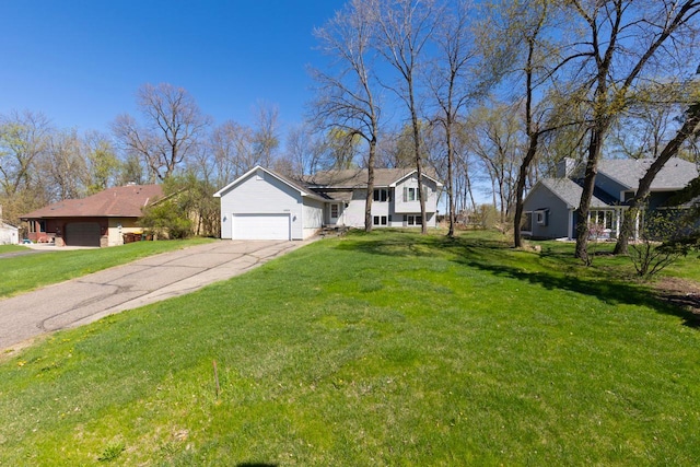 view of front of house with an attached garage, driveway, and a front lawn