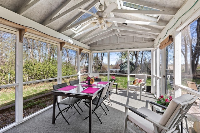 sunroom / solarium featuring outdoor dining area, a skylight, a healthy amount of sunlight, and ceiling fan