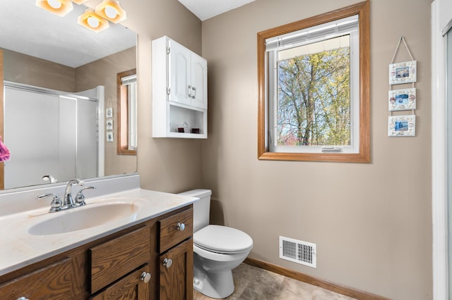 bathroom with vanity, toilet, baseboards, a shower with door, and visible vents