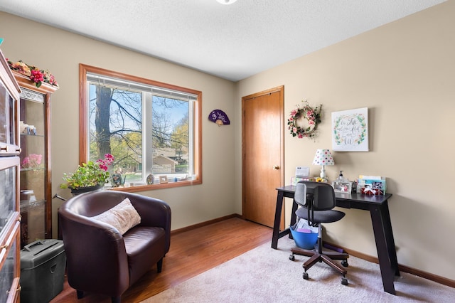 office featuring baseboards, a textured ceiling, and wood finished floors