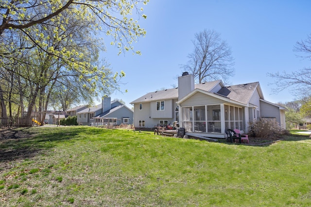 back of house with fence, roof with shingles, a sunroom, a chimney, and a lawn