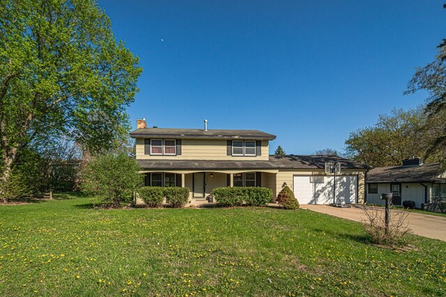 13241 Humboldt Ave S, Burnsville, MN 55337 - traditional-style house with a chimney, a garage, driveway, a front lawn, and covered porch