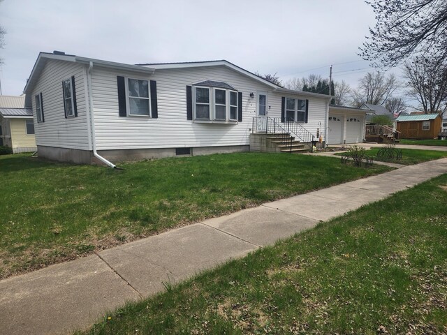 view of front of property with an attached garage, a front lawn, and driveway