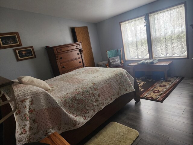 bedroom featuring wood finished floors and lofted ceiling