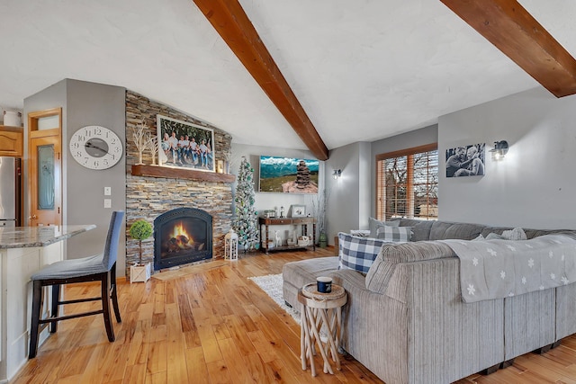 10283 Ferry Point Pl NW, Rice, MN 56367 - living area featuring a stone fireplace, vaulted ceiling with beams, and light wood-type flooring