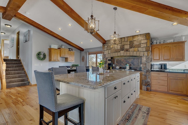 10283 Ferry Point Pl NW, Rice, MN 56367 - kitchen with a center island, lofted ceiling with beams, stainless steel microwave, light wood finished floors, and a chandelier