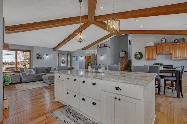 10283 Ferry Point Pl NW, Rice, MN 56367 - kitchen with a kitchen island, open floor plan, light wood-type flooring, a chandelier, and lofted ceiling with beams