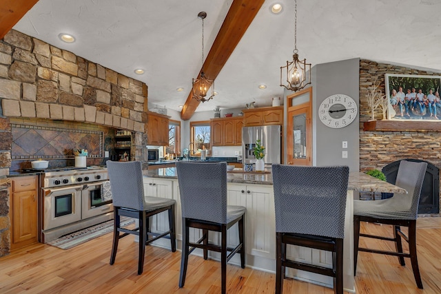 10283 Ferry Point Pl NW, Rice, MN 56367 - kitchen featuring appliances with stainless steel finishes, beamed ceiling, a notable chandelier, a breakfast bar, and light wood-style flooring