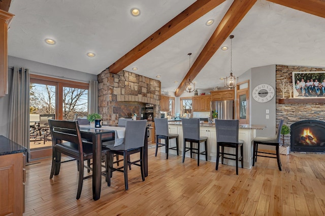 10283 Ferry Point Pl NW, Rice, MN 56367 - dining space with plenty of natural light, vaulted ceiling with beams, light wood-style flooring, and a stone fireplace
