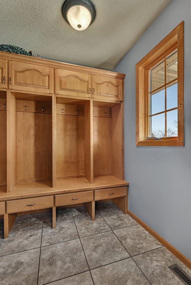 10283 Ferry Point Pl NW, Rice, MN 56367 - mudroom with baseboards, tile patterned floors, a textured ceiling, and visible vents