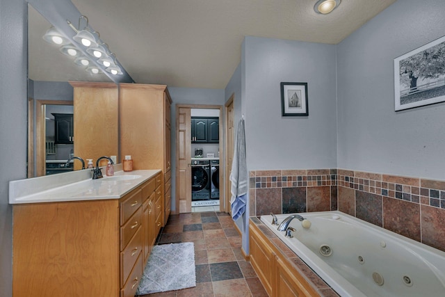 10283 Ferry Point Pl NW, Rice, MN 56367 - bathroom with vanity, stone finish floor, a tub with jets, and washing machine and clothes dryer