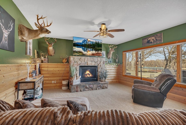 10283 Ferry Point Pl NW, Rice, MN 56367 - carpeted living area with a textured ceiling, rustic walls, a ceiling fan, and a stone fireplace