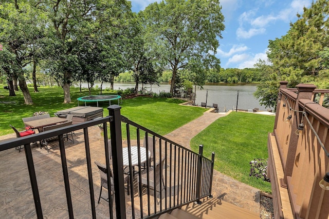10283 Ferry Point Pl NW, Rice, MN 56367 - view of green lawn featuring a trampoline, a water view, a patio, and outdoor dining area