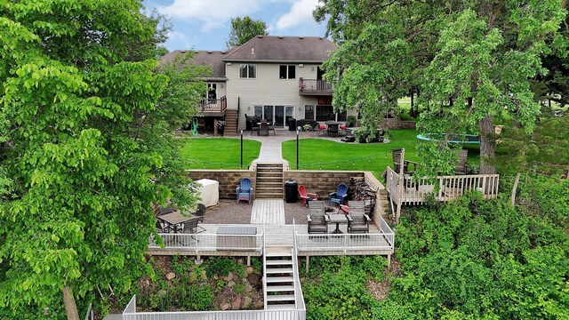 10283 Ferry Point Pl NW, Rice, MN 56367 - rear view of property featuring stairs, a wooden deck, a lawn, a patio area, and outdoor dining area