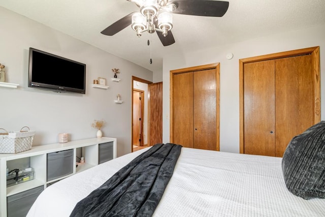 bedroom featuring a ceiling fan and two closets
