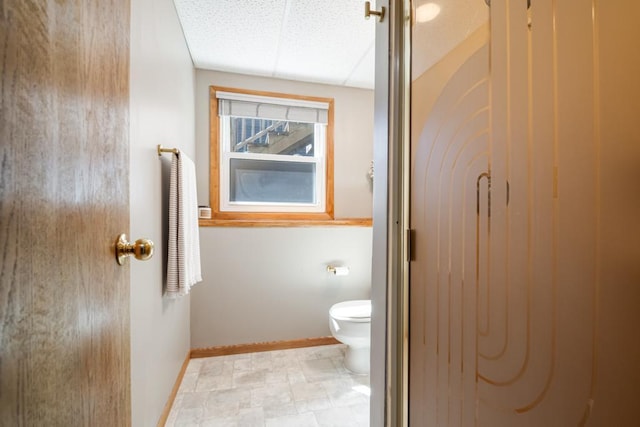 bathroom featuring baseboards and toilet