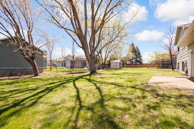 view of yard featuring a fenced backyard, an outbuilding, a patio area, a trampoline, and a storage shed