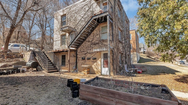 view of side of property with stairs and a vegetable garden