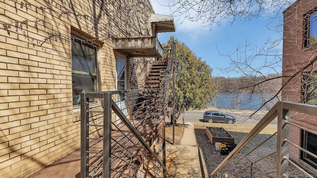 view of side of property with stairway and a water view