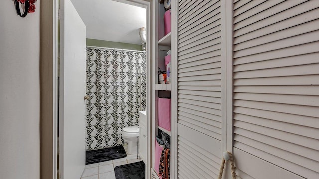 full bathroom featuring toilet, curtained shower, and tile patterned flooring