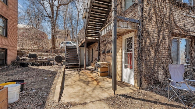 view of side of property with a patio and stairway
