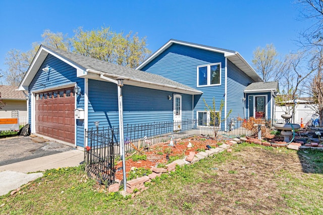 split level home featuring fence, roof with shingles, and a garage