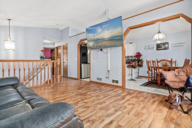 living room with visible vents, lofted ceiling, a chandelier, and wood finished floors